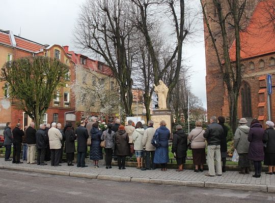 Kwiaty pod tablicą upamiętniającą ofiary 7985